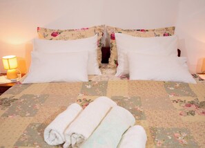 A neatly made bed with floral bedding, two white pillows, and rolled towels on the bed. - House Barat by Interhome (Rovinj/Kanfanar)
