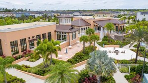 A residential area with modern houses, a central courtyard with palm trees, and a small pool. - 9096 Amazing house 6/5 W/Pool Solara Resort (Kissimmee)