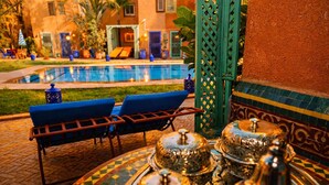 Zona de piscina con sillones de descanso y una mesa para buffet.