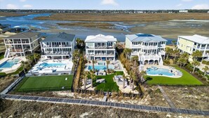 A coastal hotel with multiple buildings, each featuring balconies and swimming pools.