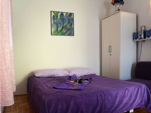 Ein Schlafzimmer mit einem Bett, einem Kleiderschrank und einem Bild an der Wand.