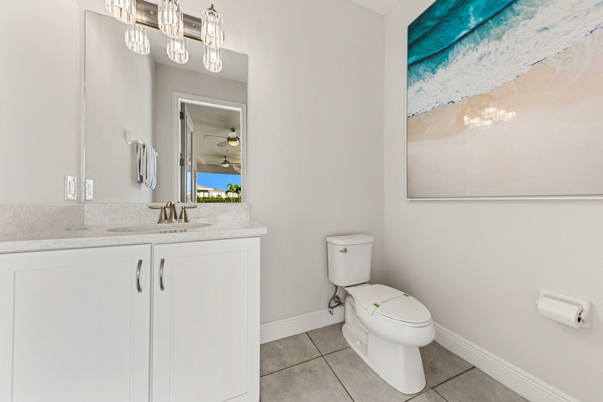 Een badkamer met een witte wasbak, spiegel en toilet.