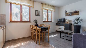 A compact living space with a dining area, a television, a sofa, and a potted plant. - Apartment 1510 by Interhome (Pula/Krnica)