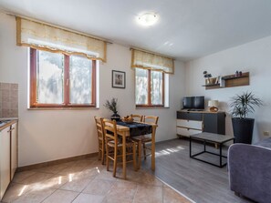 A compact living space with a dining area, a television, a sofa, and a potted plant. - Apartment 1510 by Interhome (Pula/Krnica)
