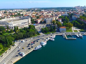 An aerial view of a city with a prominent historical building, a marina with boats, and a mix of residential and commercial buildings. - Apartment 1510 by Interhome (Pula/Krnica)