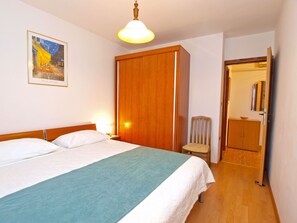 Ein Hotelzimmer mit einem Bett, einem Sessel, einem Schrank und einem Bild an der Wand.