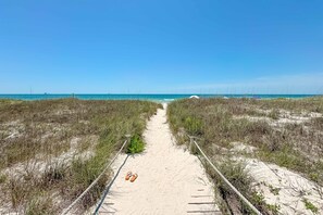 A sandy beach path leading to the ocean, flanked by grass and wooden railings. - Ft. Morgan Beachfront home - Gulf views, Pools (Gulf Shores)