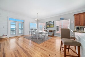 A spacious room with a dining area, a kitchen, and a view of the beach. - Ft. Morgan Beachfront home - Gulf views, Pools (Gulf Shores)