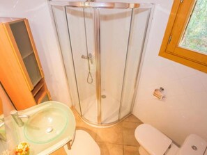 A bathroom with a glass shower enclosure, a sink, and a toilet. - Vacation home Buger by Interhome (Búger)