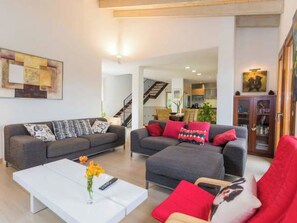 Ein modernes Wohnzimmer mit einer Sofagarnitur, einem Couchtisch und einem Bücherregal.