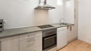 A modern kitchen with a stainless steel range hood, a built-in oven, a dishwasher, and a sink. - Manyo Petit by Interhome (Sa Pobla)