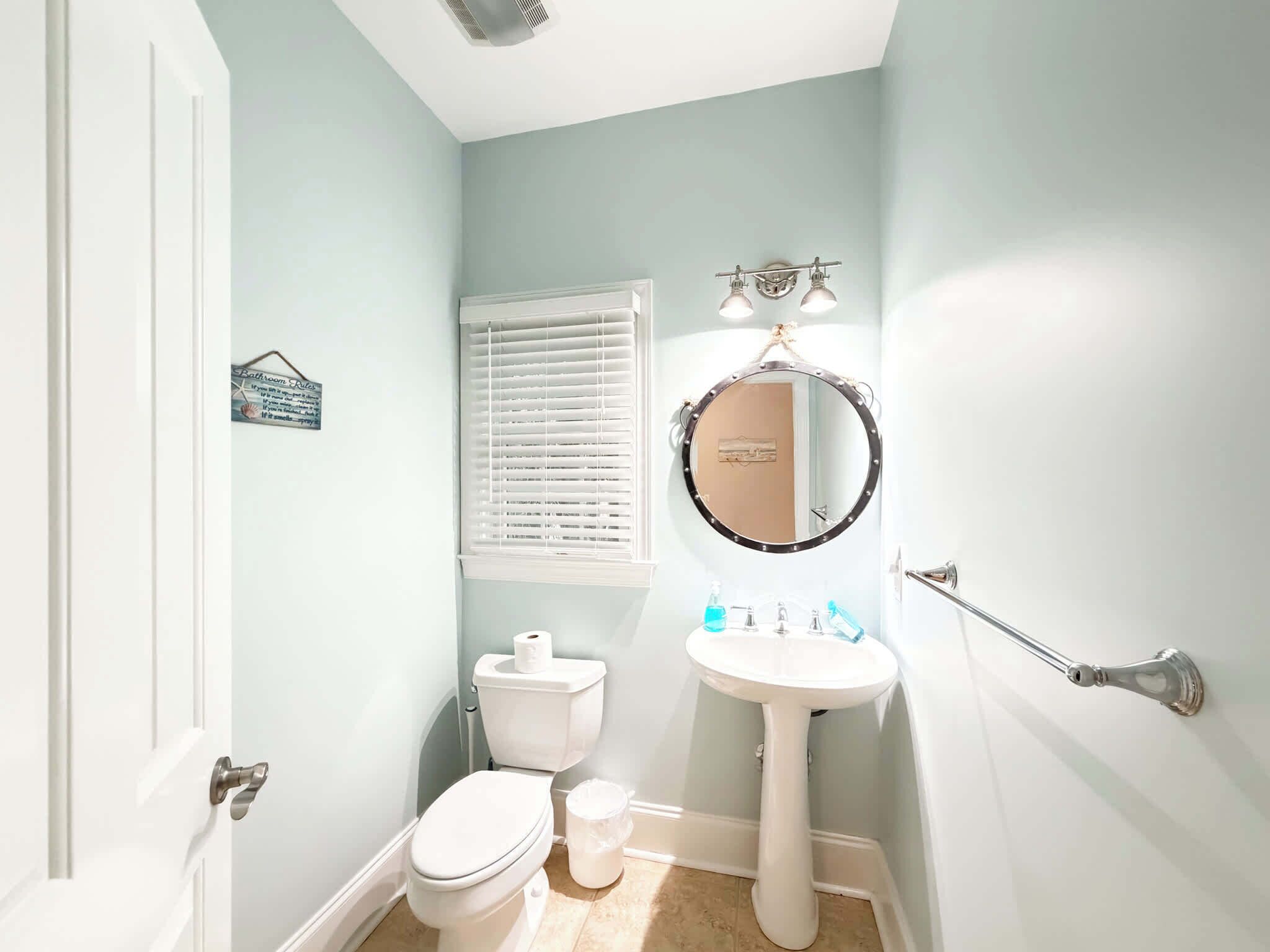 A small bathroom with a toilet, sink, and mirror.