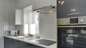 Une cuisine moderne équipée d’appareils électroménagers en acier inoxydable, d’un four encastré et d’un four à micro-ondes.