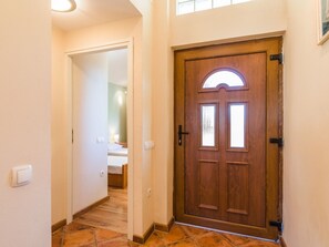 A hallway leading to a bedroom with a wooden door, a light switch, and a tiled floor. - Irena Apartments 2 kat / HR-10649-02 by Interhome (Selce)