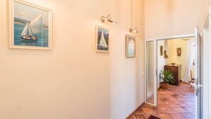 A hallway with framed maritime paintings, a tiled floor, and a door leading to another room. - Irena Apartments 2 kat / HR-10649-02 by Interhome (Selce)