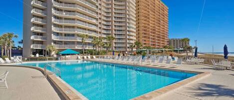 Una piscina amb gandules i un edifici alt al fons.
