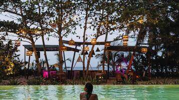 Una piscina al aire libre, sillones reclinables de piscina