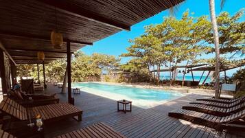 Een buitenzwembad en ligstoelen