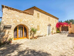 A stone building with arched windows and a courtyard. - Manenta by Interhome (Manacor)