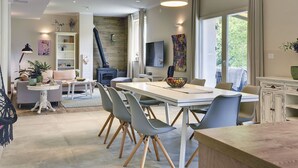 Un espace de salle à manger moderne avec une longue table, des chaises et une cheminée.