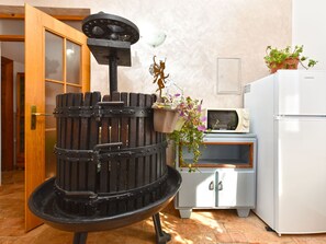 A room with a black stove, a microwave, a refrigerator, and a door with a window. - Apartment 1945 by Interhome (Rovinj/Bale)