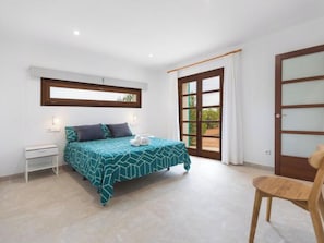 A bedroom with a bed, a chair, a window, and a door. - Vacation home Vivot by Interhome (Búger)