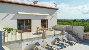 A modern building with a balcony, sun loungers, and a view of greenery. - Vacation home Vivot by Interhome (Búger)