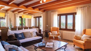 A spacious living room with a sofa, armchairs, a coffee table, and a view of the outdoors. - Maribel by Interhome (Inca)