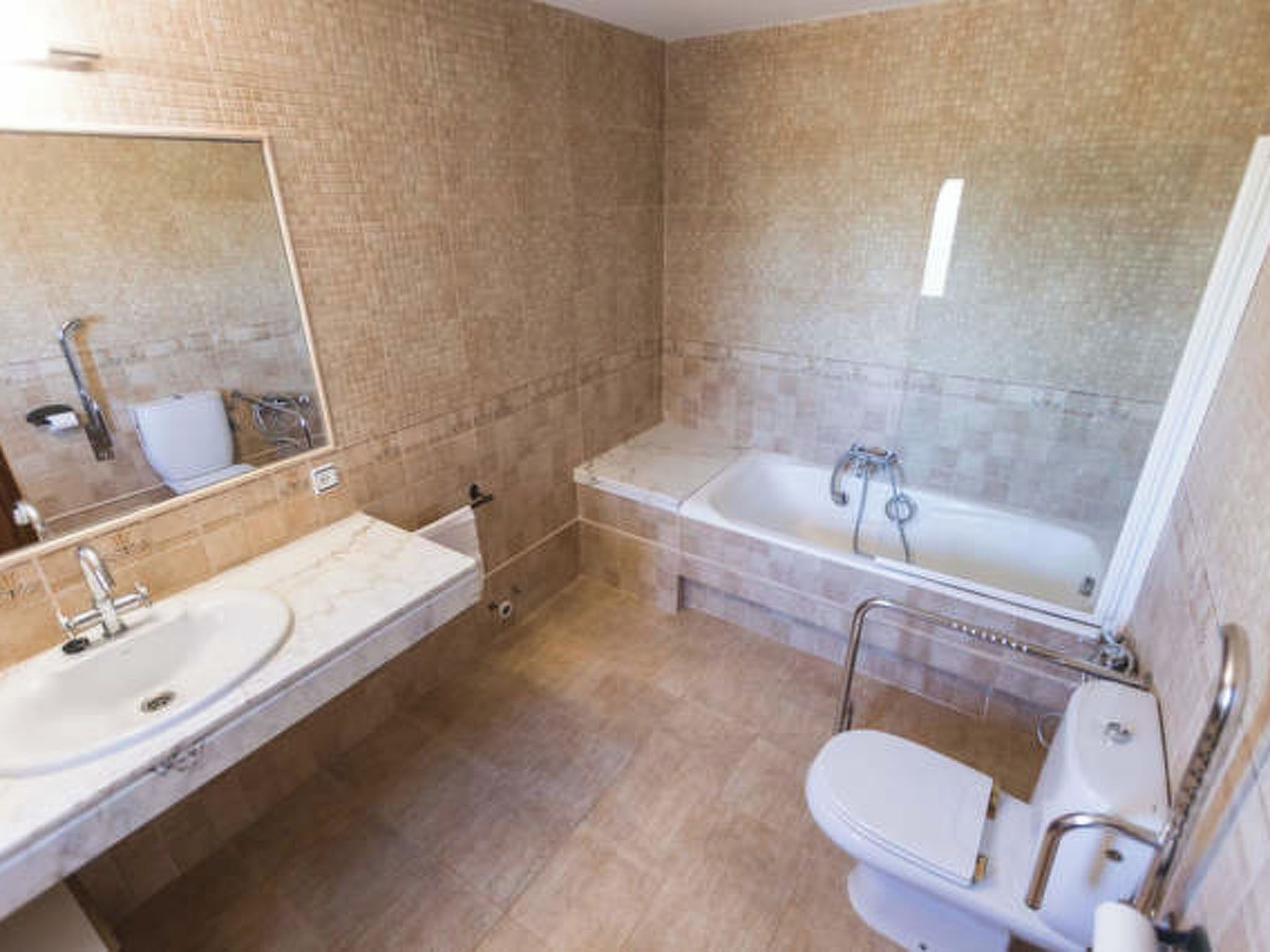 A bathroom with a sink, toilet, and bathtub.