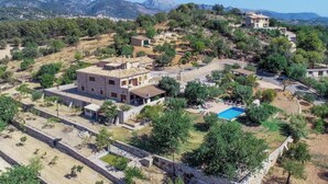 A residential area with houses, a swimming pool, and a mountainous backdrop. - Maribel by Interhome (Inca)