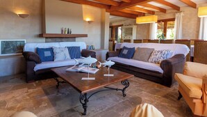 A living room with two sofas, a coffee table, and a fireplace. - Maribel by Interhome (Inca)