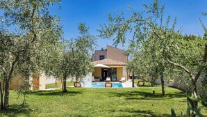 A modern house with a swimming pool, surrounded by olive trees and a well-maintained lawn. - Villa Markulin by Interhome (Bokordici)