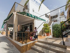 Ein Gebäude mit einer Bar und einem Restaurant im Erdgeschoss, Außenplätzen und einer Treppe zu einer oberen Ebene.