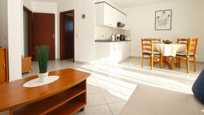 A modern living room with a dining area, a kitchen, and a hallway. - Apartment 1978 by Interhome (Dracevac)