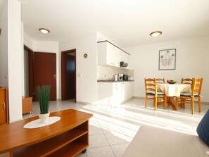 Ein modernes Wohnzimmer mit Essbereich, einer Küche und einem Flur.