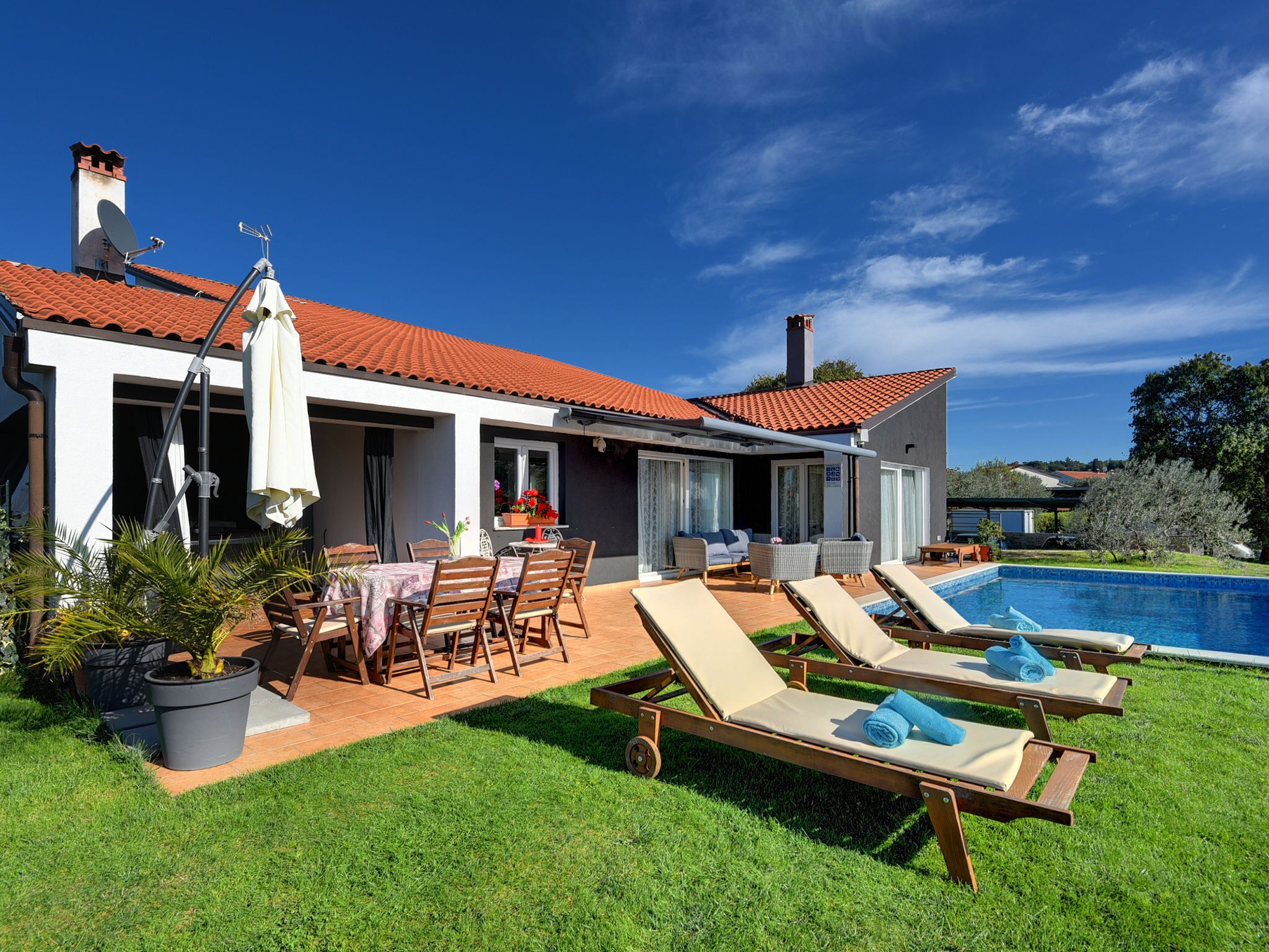 A house with a swimming pool, outdoor furniture, and a patio area.