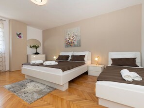 A modern hotel room with a large bed, two bedside tables, a small desk, and a decorative painting. - House 2036 by Interhome (Rabac)