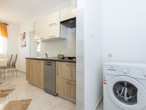 A modern kitchen with a dishwasher, a stove, and a washing machine. - House 2036 by Interhome (Rabac)