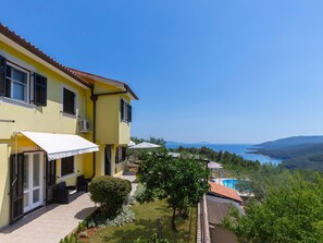 A yellow villa with a pool, a covered patio, and a view of the sea. - House 2036 by Interhome (Rabac)