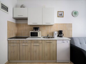 A compact kitchen with a microwave, coffee maker, and dishwasher. - Apartment 294 by Interhome (Drenje)