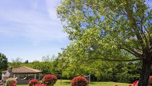 A garden with a gazebo, a large tree, and red foliage. - Villa Morena by Interhome (Jakovici)