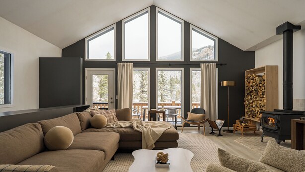 Ein modernes Wohnzimmer mit einer großen Eckcouch, einem Couchtisch und einem Kamin.