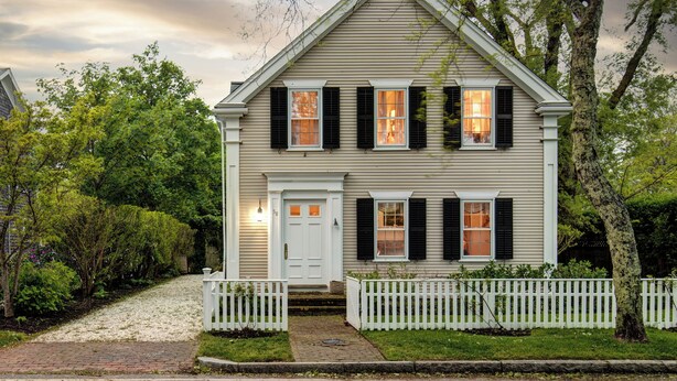 A two-story house with a white front door, a small porch, and a white picket fence. - Pau Hana - Spacious 4-bedroom house in quaint Nantucket with AC (Nantucket)