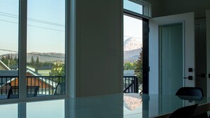 Una habitación con ventanas amplias que ofrecen vistas a un paisaje montañoso.
