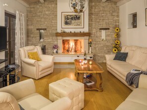 A living room with a fireplace, leather sofas, a coffee table, and a TV. - Villa Kanco by Interhome (Pula/Manjadvorci)