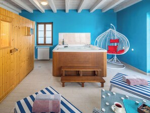 A modern bathroom with a wooden bathtub, a hanging chair, and a bench. - Villa Kanco by Interhome (Pula/Manjadvorci)