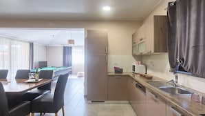 A modern kitchen with a dining area, a pool table, and a refrigerator. - Villa Amber by Interhome (Pula/Manjadvorci)