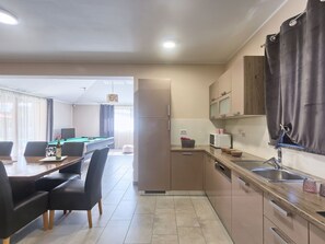 A modern kitchen with a dining area, a pool table, and a refrigerator. - Villa Amber by Interhome (Pula/Manjadvorci)