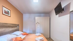 A hotel room with a bed, a wardrobe, a television, and a framed picture on the wall. - Villa Amber by Interhome (Pula/Manjadvorci)