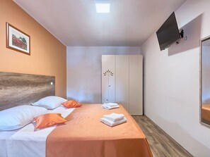A hotel room with a bed, a wardrobe, a television, and a framed picture on the wall. - Villa Amber by Interhome (Pula/Manjadvorci)